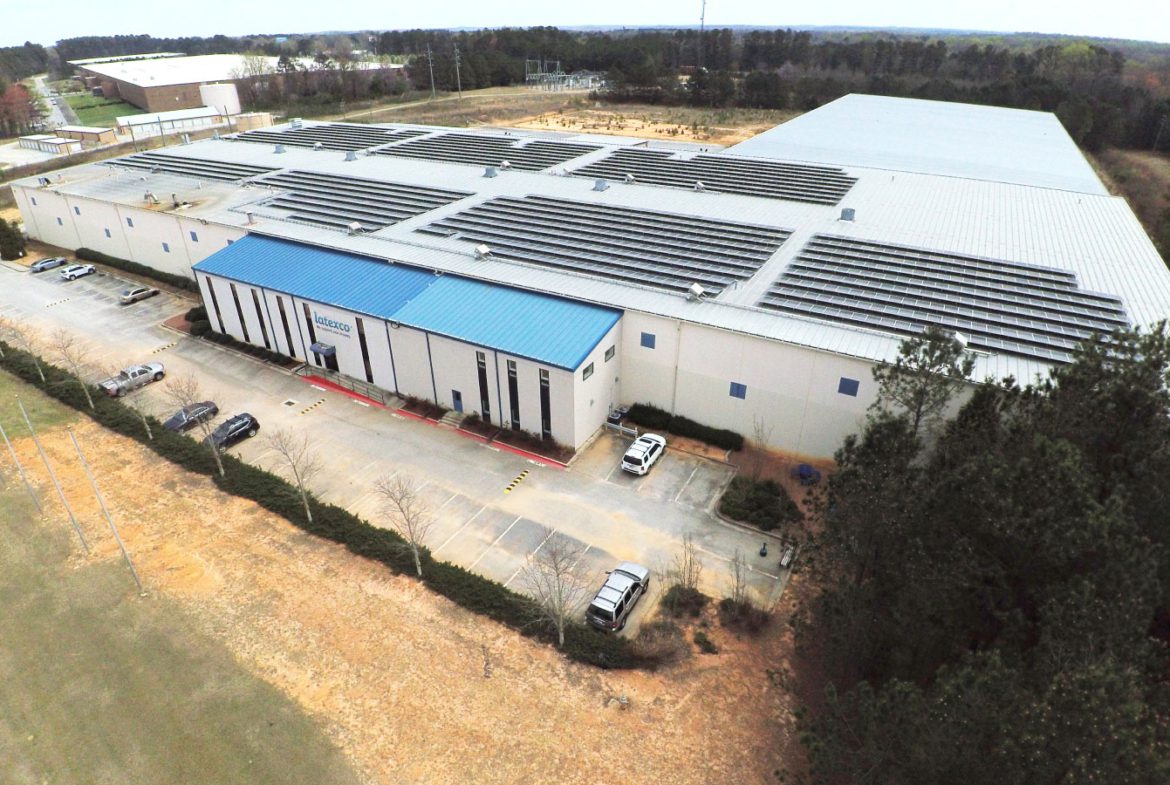 A large warehouse with solar panels on the roof.