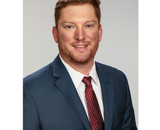 A man in a suit and tie smiling for the camera.